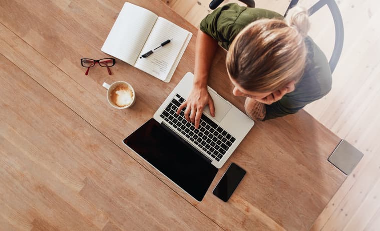 Woman typing on laptop at home