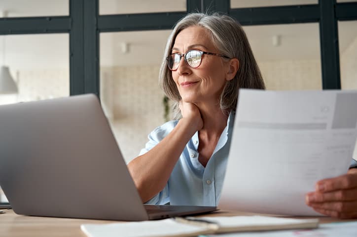 Kvinde med gråt hår kigger på computer