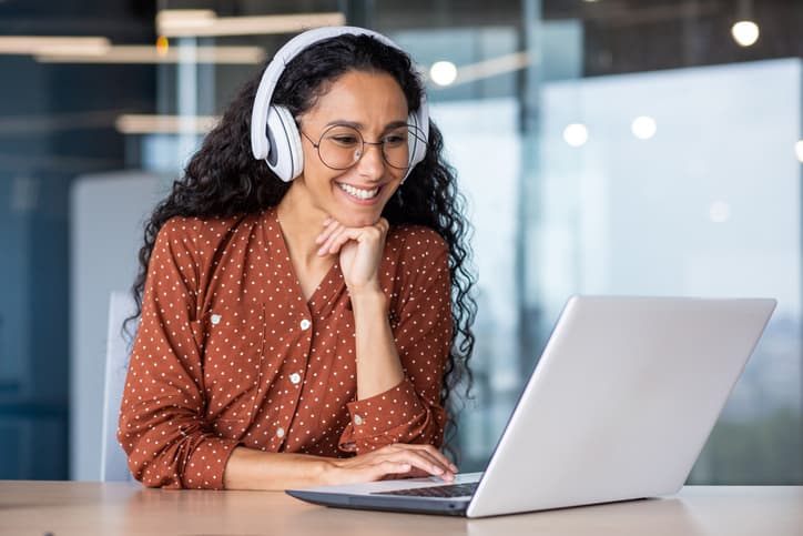 Kvinde på kontor foran pc og med headset