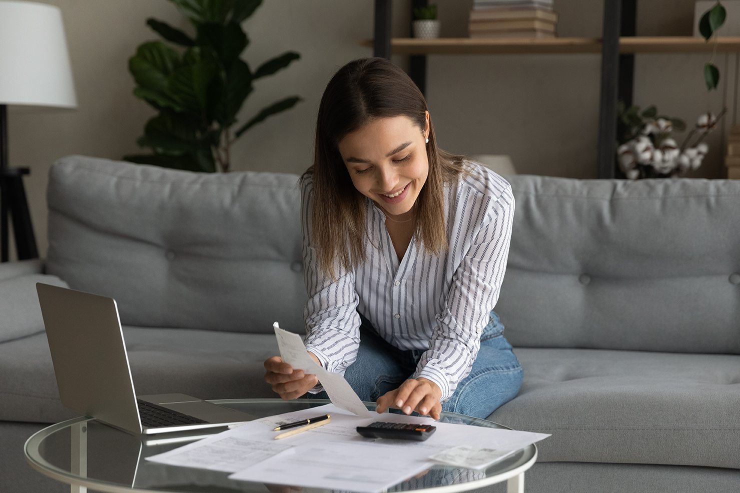 Woman sitting in a couch and looking at papers