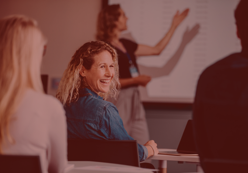 Kvinde smiler under undervisning på kursus