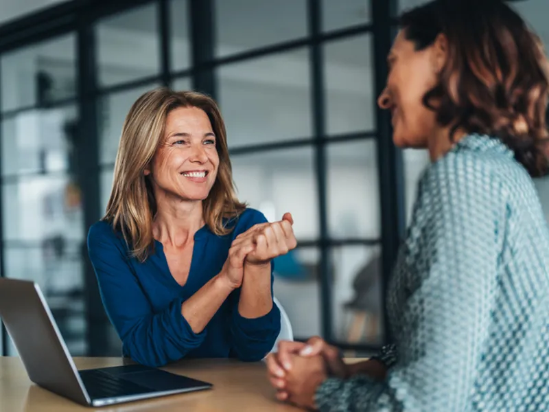 Two female colleagues talking in an office